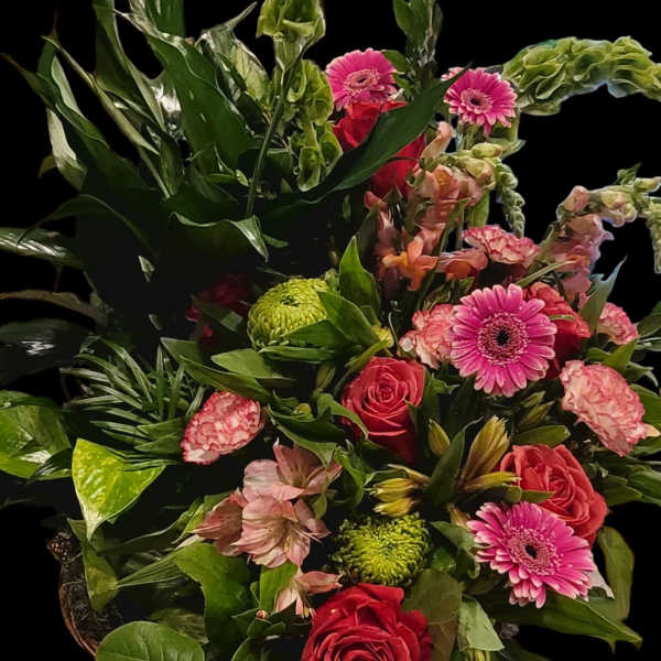 Mixed bouquet with pink gerberas, red roses, and green blooms