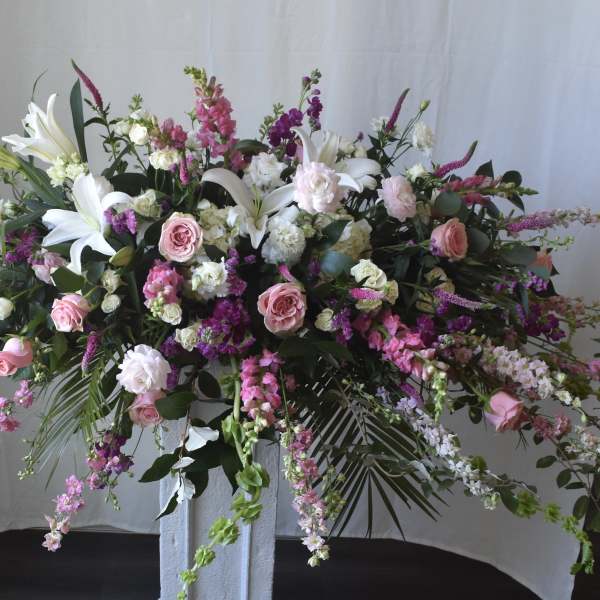 Large floral spray with pink and white flowers on a pedestal