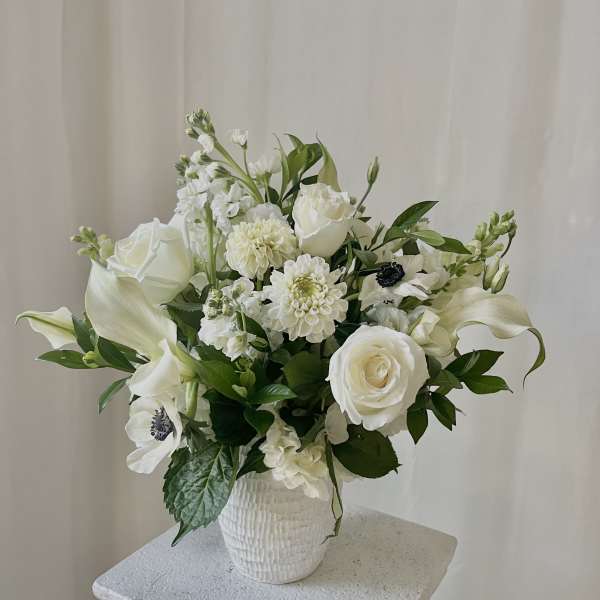 White floral arrangement in a textured white vase