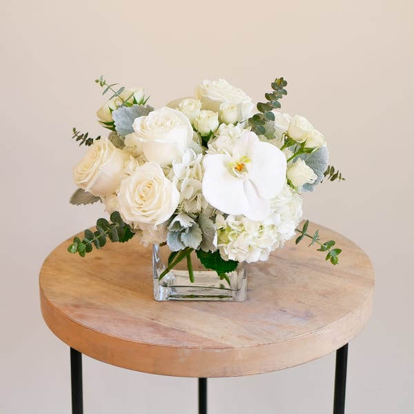 White rose bouquet in a square glass vase