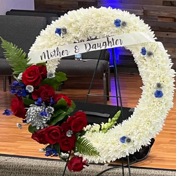 Heart-shaped floral tribute with white chrysanthemums and red roses