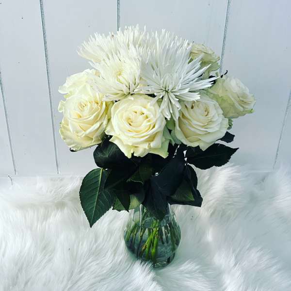 White roses and spider mums in a glass vase