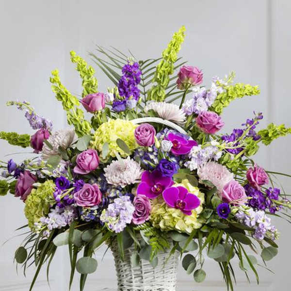 Large basket arrangement of purple, pink, and white flowers
