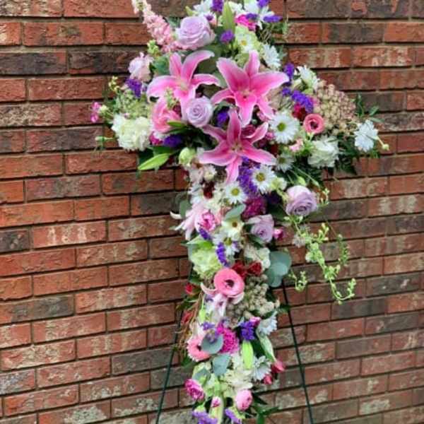 Tall cross-shaped floral spray with pink lilies and mixed blooms