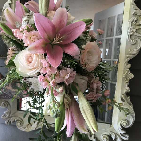 Pink lilies and pale roses in a hand-tied bouquet