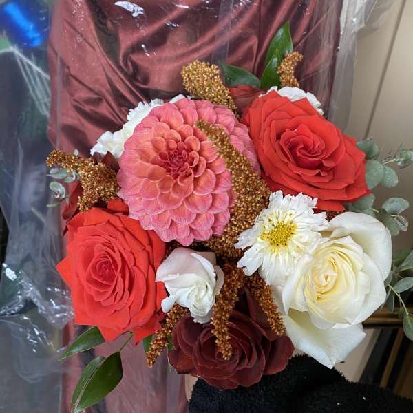 Bouquet of red, white, and pink roses with a pink dahlia