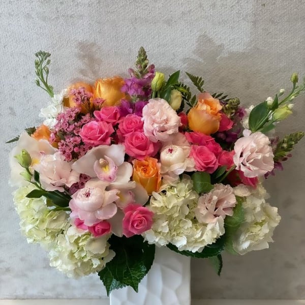 Mixed pink, peach, and white bouquet in a white vase