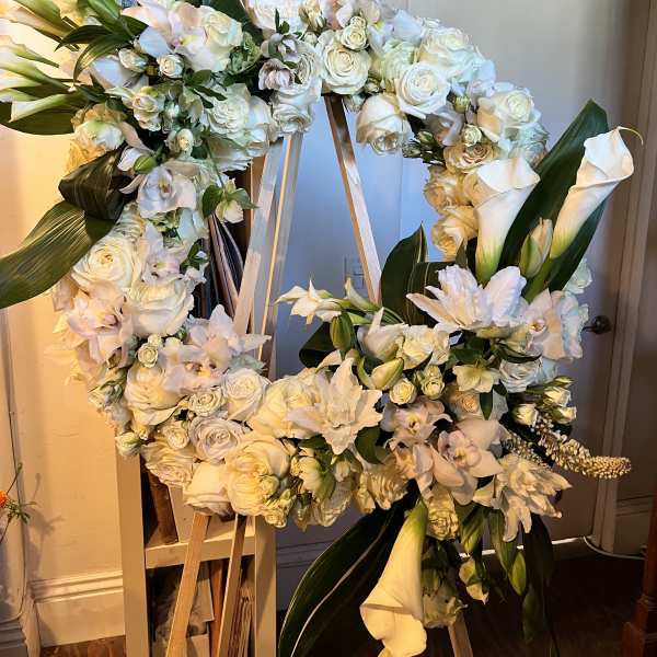Large white floral wreath on a wooden easel