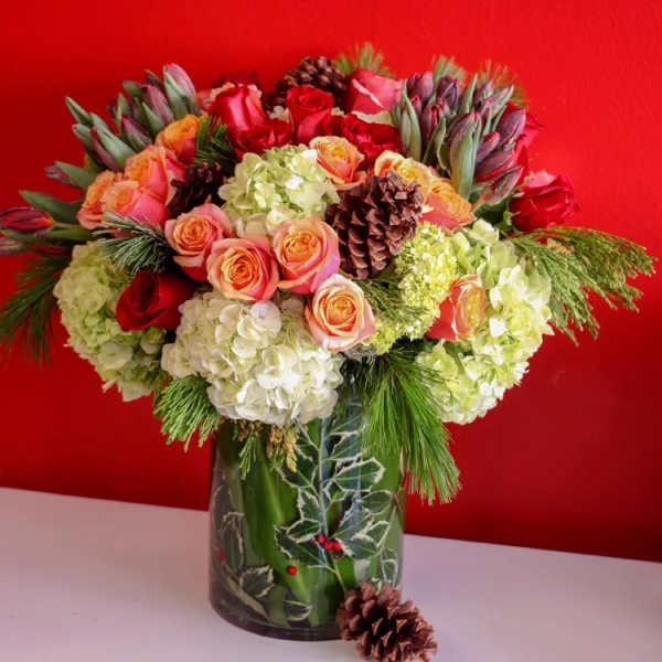 Bouquet of roses and hydrangeas in a holiday vase with pinecones