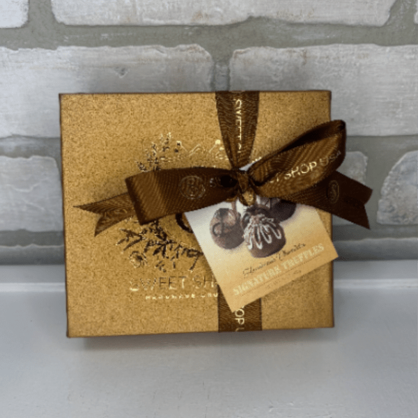 Gold chocolate gift box with brown ribbon and truffle tag