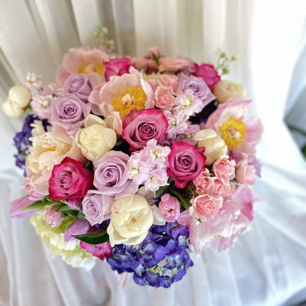Bouquet of pink, lavender, and cream flowers with roses and hydrangeas