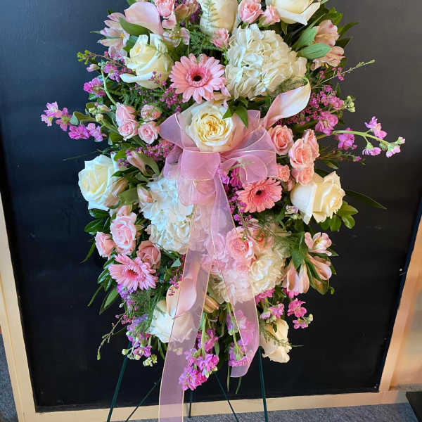 Pink and white floral standing spray with a ribbon bow