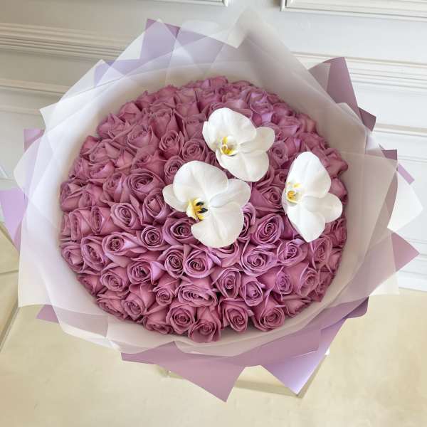 Round bouquet of pink roses with three white orchids