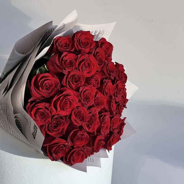 Bouquet of red roses wrapped in white paper