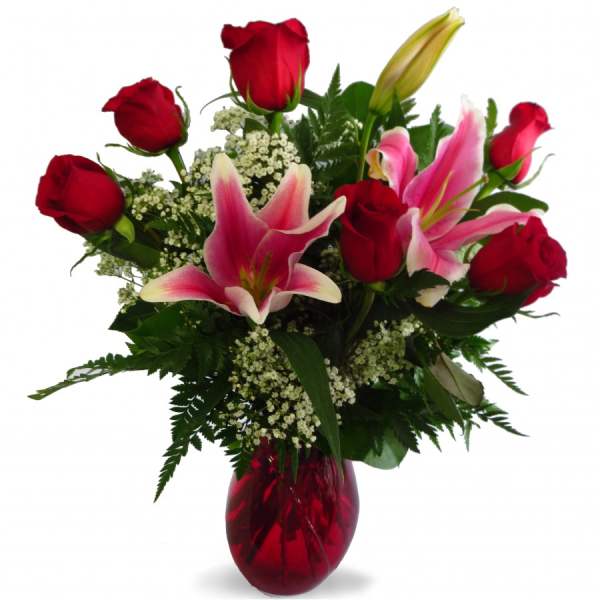 Red roses and pink lilies in a red glass vase