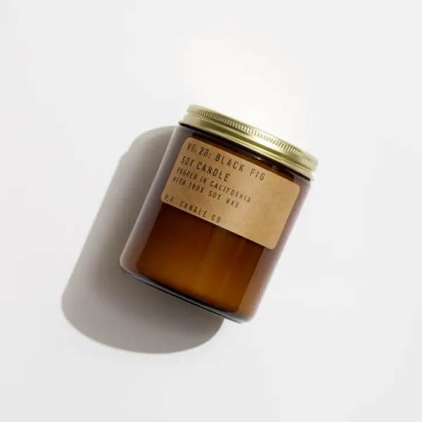 Amber glass candle jar with a gold lid and paper label