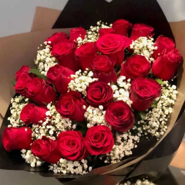 Bouquet of red roses with white baby's breath in black wrapping