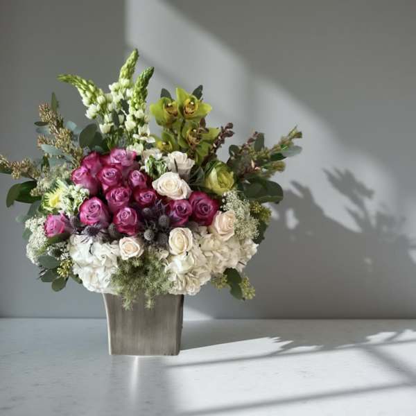 Bouquet of pink and white roses in a square vase