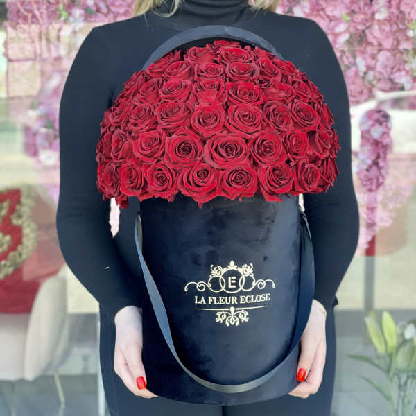 Large red rose arrangement in a black hatbox