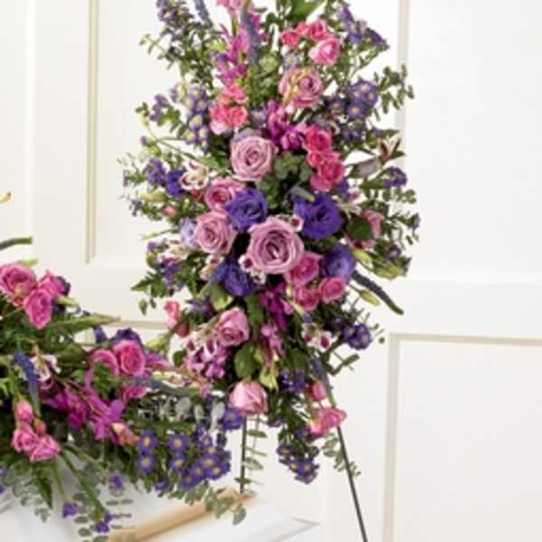 Tall arrangement of pink and purple flowers on a stand