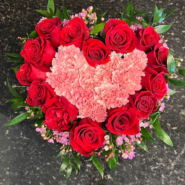 Heart-shaped bouquet of red roses and pink carnations