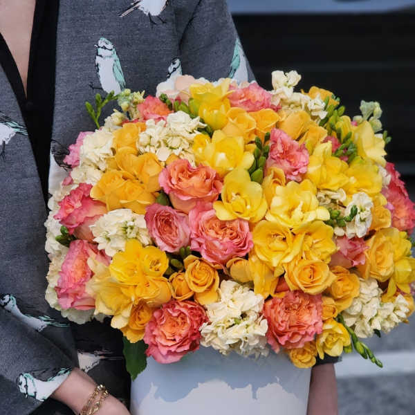 Bouquet of yellow, pink, and white roses in a white box