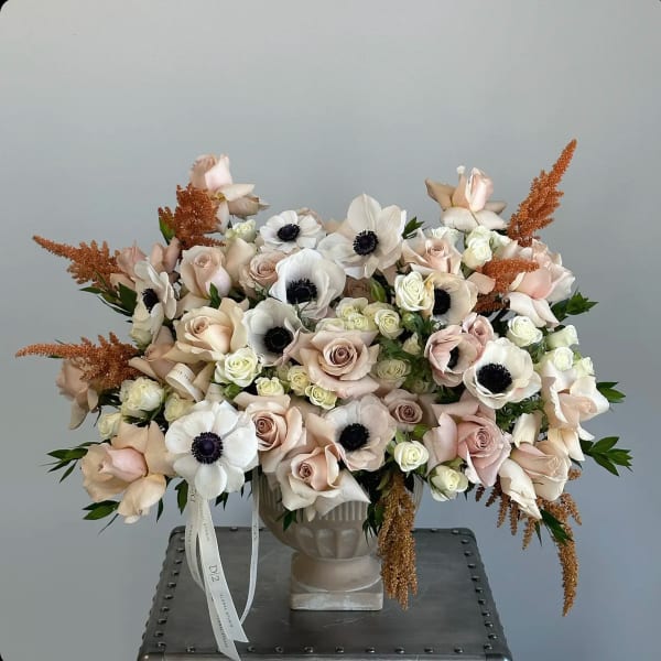 Blush and white floral arrangement in a pedestal vase