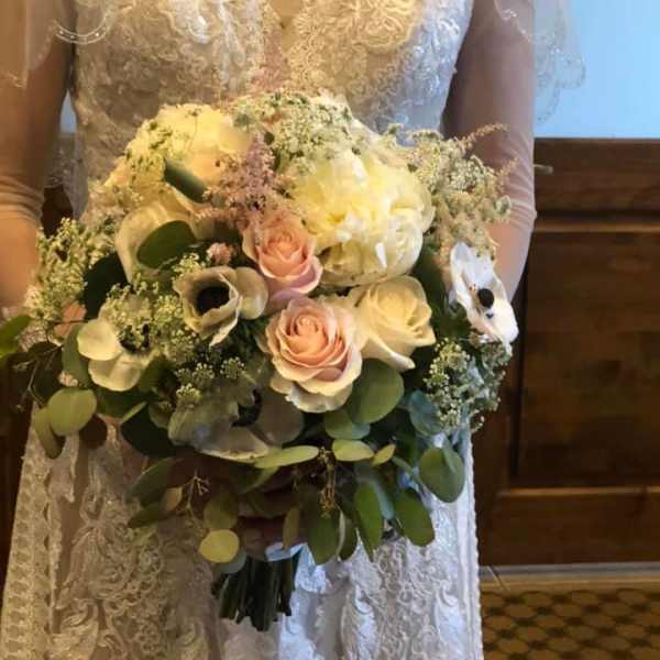 Bride holding a bouquet of white and blush flowers