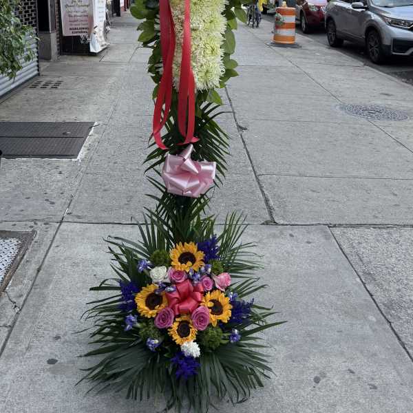 Tall floral standing cross with mixed flowers and ribbons