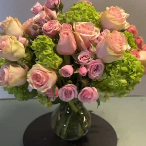 Pink roses and green hydrangeas in a glass vase