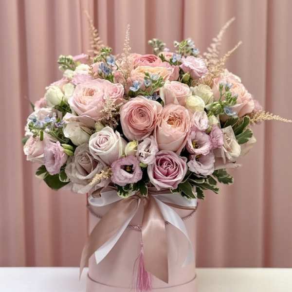 Pink and cream rose bouquet in a round hatbox with ribbon
