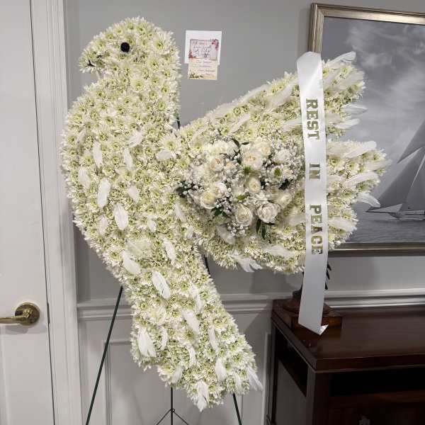 White floral peace sign funeral spray with a ribbon and roses