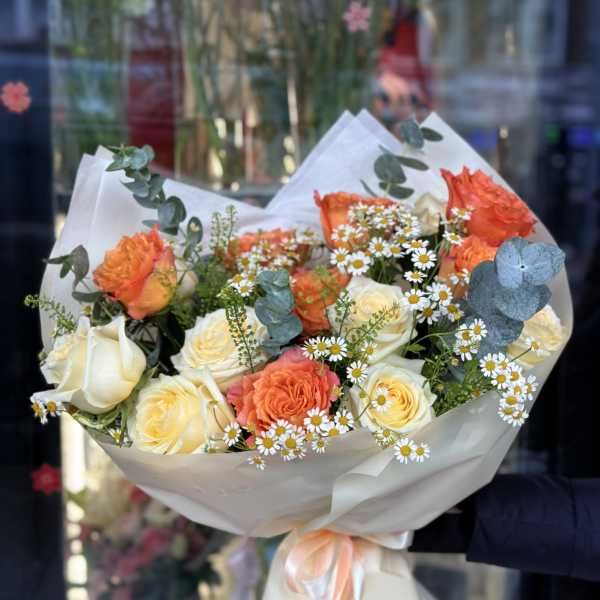 Bouquet of orange and white roses with small white daisies