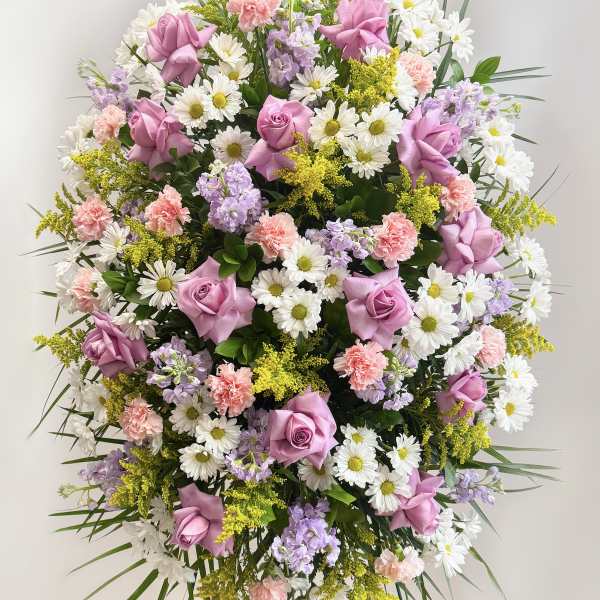 Large standing spray of pink roses, white daisies, and pastel flowers