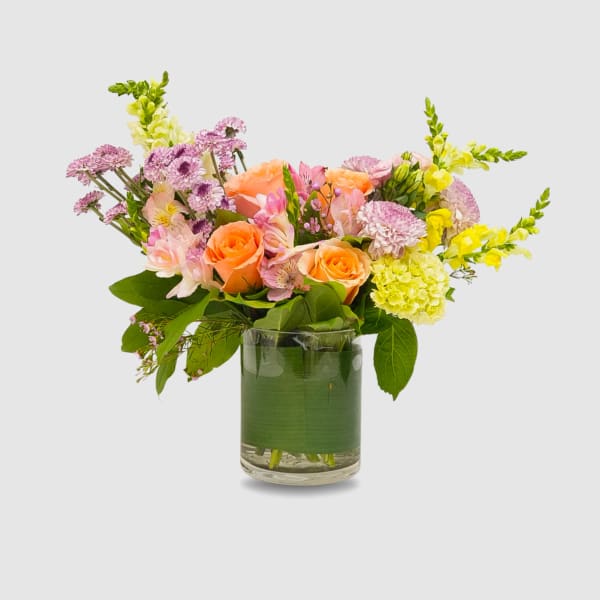 Bouquet of peach and pink flowers in a clear glass vase