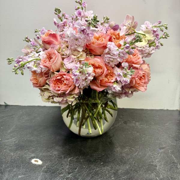 Pink and peach bouquet in a round glass vase