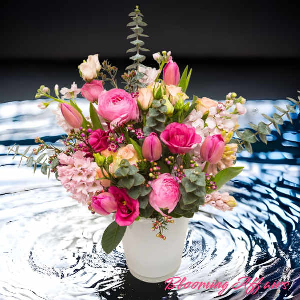 Pink and peach mixed bouquet in a white vase