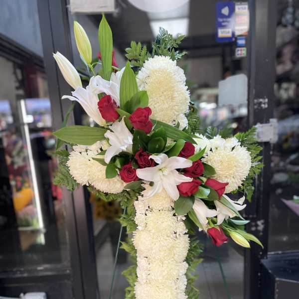 White lilies and red roses in a tall standing spray