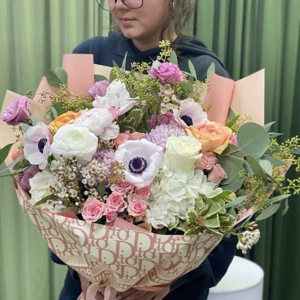 Large bouquet of pink, white, and peach flowers wrapped in patterned paper