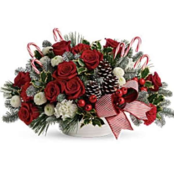 Red roses and holiday accents in a white bowl