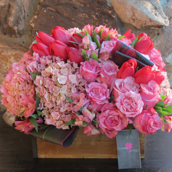 Pink and red bouquet with roses, tulips, and hydrangeas in a box
