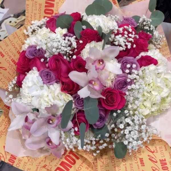 Bouquet of pink and white roses with pale orchids and eucalyptus