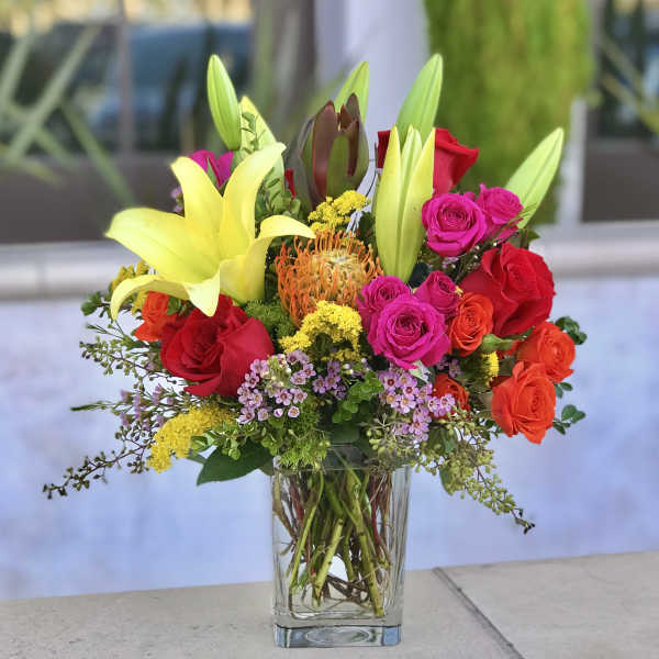Mixed bouquet of lilies and roses in a clear glass vase