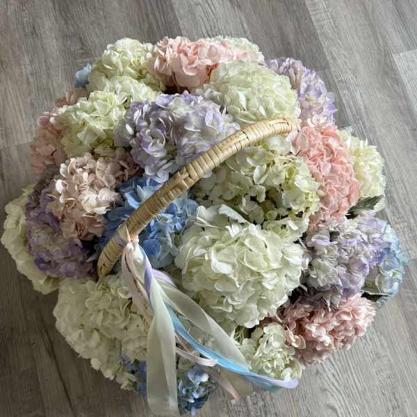 Basket of pastel hydrangeas with ribbon handles