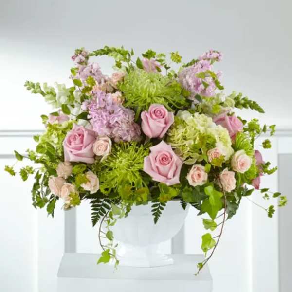 Pink roses and lavender flowers in a white vase
