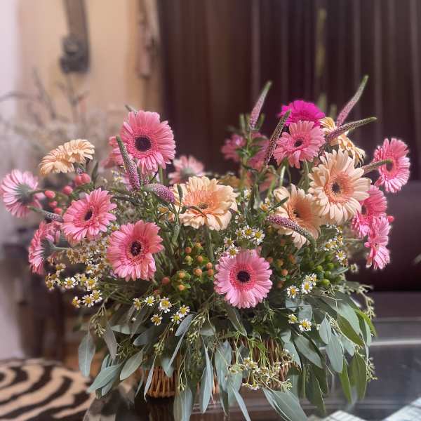 Pink and peach gerbera bouquet in a low basket arrangement