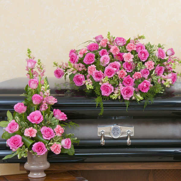 Pink floral sprays arranged around a black casket