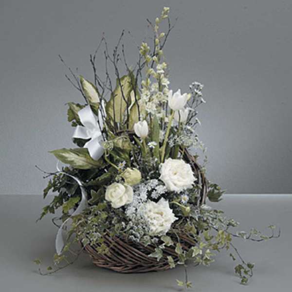 White floral arrangement in a wicker basket with ribbon
