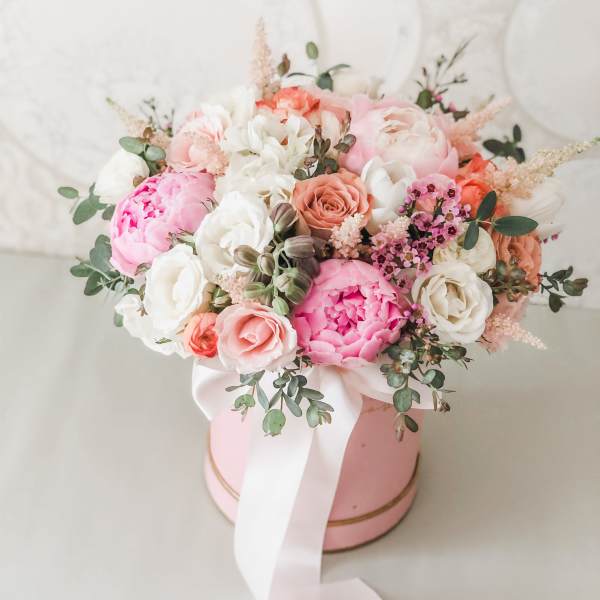 Pink and white bouquet in a round pink box with a white ribbon