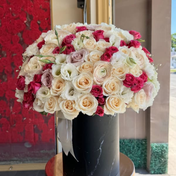 Large bouquet of cream and pink roses in a black vase